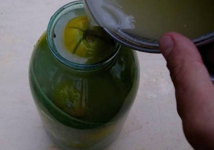 Саламурата се излива в буркана Залейте доматите със саламурата